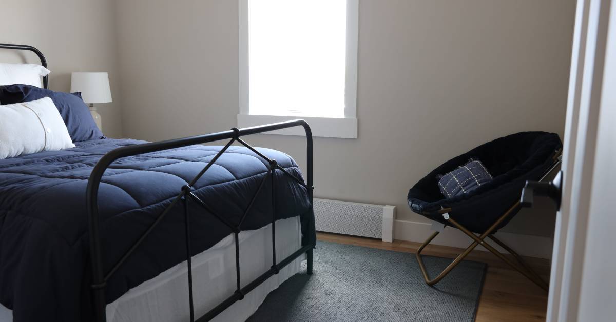 Contemporary bedroom featuring a sleek metal bed frame, layered bedding, and clean modern finishes, creating a comfortable and inviting retreat.